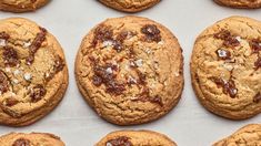 chocolate chip cookies are lined up on a baking sheet