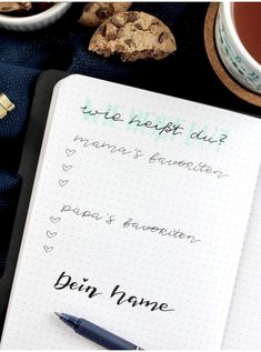 a notepad with writing on it next to a cup of coffee and cookie cookies