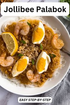 a white plate topped with rice and shrimp next to lemon wedges on top of a table