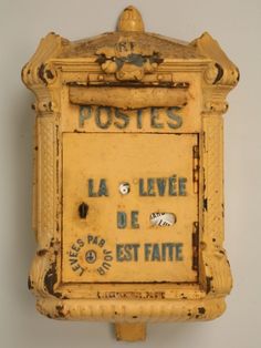 an old yellow post box mounted on the wall