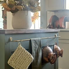 pots and pans are hanging on a rack in the kitchen