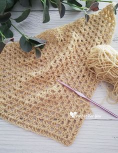 a crocheted piece of cloth next to a knitting needle