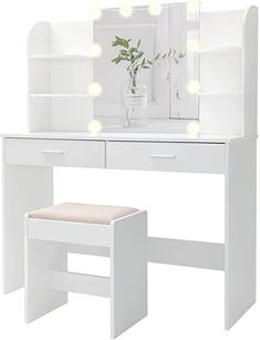 a white dressing table with lights on it and a stool in front of the mirror