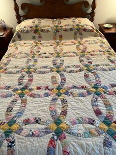 a bed with a quilt made into the shape of an o on it's headboard