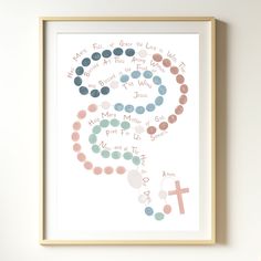 a framed print with the words and cross on it, in pastel colors against a white wall