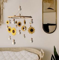 a sunflower mobile hanging from a wall next to a mirror