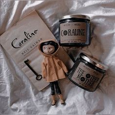 a doll is posed next to two jars of cream