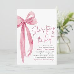 a pink bow is on the front of this wedding card with text that reads she's tying the knot