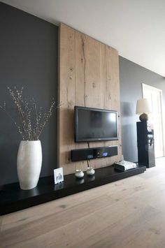 a living room filled with furniture and a flat screen tv on top of a wooden shelf