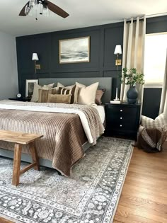 a bedroom with black walls and white bedding has a rug on the wooden floor