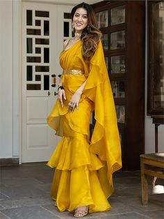 Introducing our glamorous yellow organza ready-to-wear ruffle saree with blouse! This stunning ensemble is crafted from high-quality organza material in a beautiful yellow color. The saree is stitched in layers, creating a chic and fashionable look that is sure to turn heads.
One of the key features of this saree is the golden color organza material sleeveless blouse. It is adorned with intricate sequin work, adding a touch of glamour and sophistication. The sequins sparkle and shimmer as they c Bollywood Style Ruffled Organza Pre-draped Saree, Party Wear Ruffled Organza Sharara, Organza Pre-draped Saree With Ruffles For Diwali, Diwali Organza Saree With Ruffles, Diwali Ruffled Organza Saree, Gold Fitted Organza Pre-draped Saree, Yellow Organza Pre-draped Saree For Party, Gold Organza Pre-draped Saree For Parties, Festive Organza Saree With Ruffles