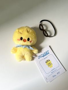 a yellow stuffed animal sitting next to a pair of scissors on a white table top