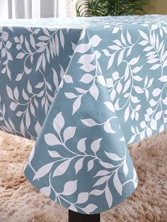 a blue table cloth with white leaves on it and a brown rug in the background