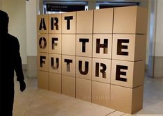 a man standing in front of a sign that says art of the future