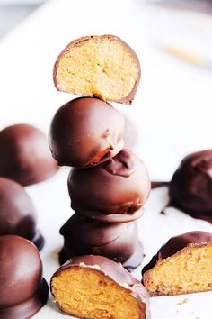 chocolate covered donuts stacked on top of each other with one bite taken out of it