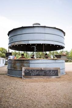 a large metal water tank sitting on top of a dirt field