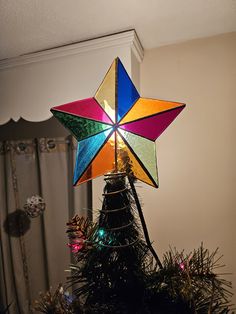 a multicolored star on top of a christmas tree