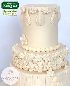 a three tiered cake decorated with white flowers