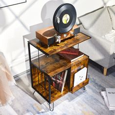 a record player sitting on top of a wooden table next to a couch and chair