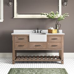 a bathroom vanity with a mirror above it and a rug on the floor next to it