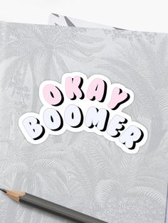 sticker with the words okay boomer written in pink and black on it next to a pencil