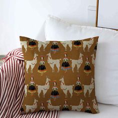 a decorative pillow with llamas on it and a striped throw pillow in the background