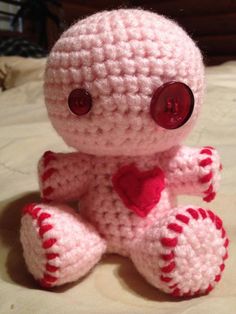 a crocheted pink teddy bear with a red heart on it's chest