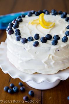 a white cake with blueberries and lemon on top