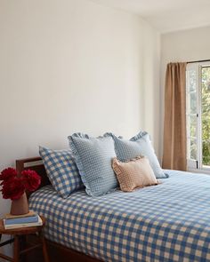 a blue and white checkered bedspread in a bedroom with a large window