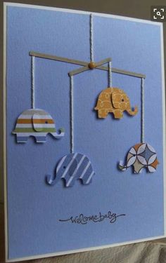 a card with elephants and giraffes hanging from strings