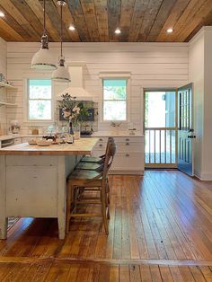 a kitchen with wooden floors and white walls