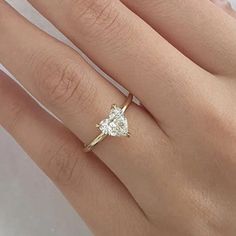 a woman's hand with a diamond ring on top of her finger and an engagement band