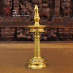 a golden candle holder sitting on top of a wooden table