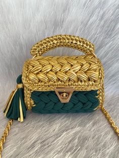 a green and gold handbag sitting on top of a white furnishce covered floor