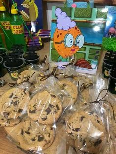 chocolate chip cookies are wrapped in plastic on a table with children's books and toys