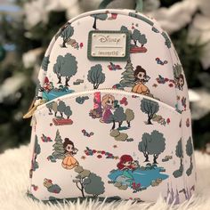 a white backpack with disney characters on it sitting on a furnishing area next to a christmas tree