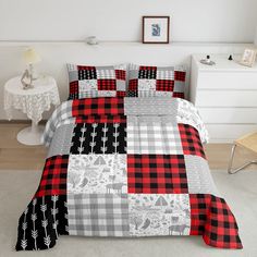 a bed with red and black plaid comforter set on top of white rugs