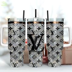 three louis vuitton travel mugs are shown with the same pattern on them