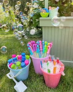 several buckets filled with lots of different colored toothbrushes and soapy bubbles