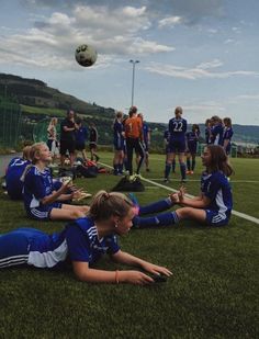 the soccer players are sitting on the grass and talking to each other as they play