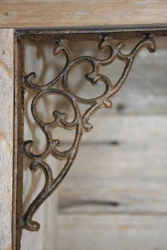 an ornate iron shelf with wood paneling in the background