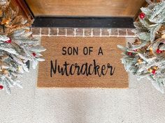 a door mat that says son of a nutcracker surrounded by christmas wreaths