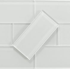 a white tile wall that has two square tiles on the bottom and one rectangular in the middle