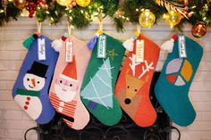 christmas stockings hanging from a fireplace with decorations