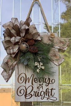 a wooden sign that says merry and bright hanging from a door with pineconis