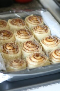 rolls wrapped in plastic sitting on top of a pan