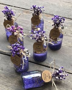 purple flowers in glass bottles with tags on them