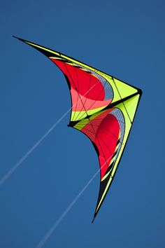 a colorful kite is flying in the blue sky