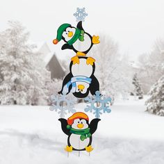 three penguins with hats and scarfs are standing in the snow