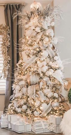 a white christmas tree with gold and silver ornaments